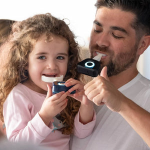 A man and a child brushing their teeth